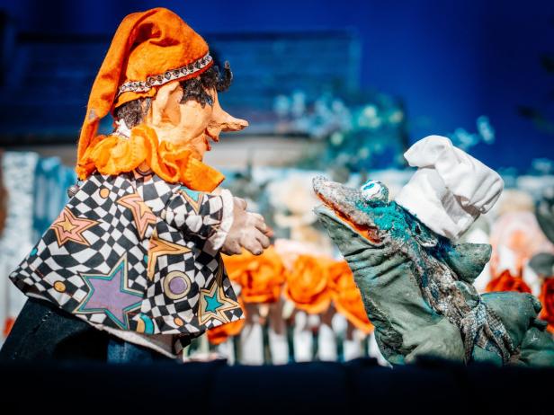 Ein Kasperletheater mit einer Krokodilpuppe mit Kochmütze.