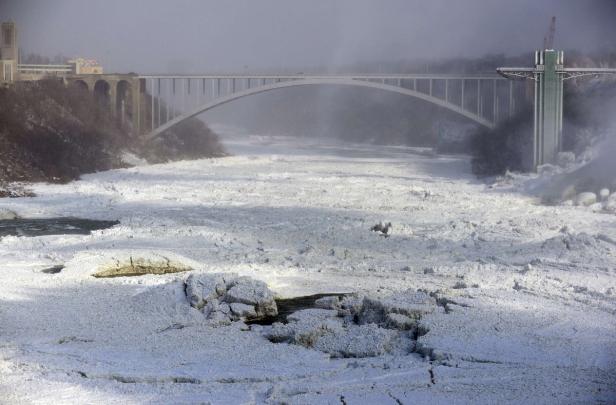 Der Niagarafluss ist mit Eis bedeckt, im Hintergrund eine Brücke.