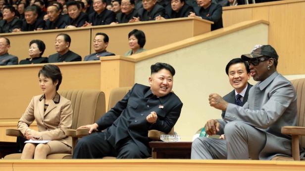 Kim Jong-un und Dennis Rodman sitzen zusammen mit anderen Personen auf einer Tribüne.