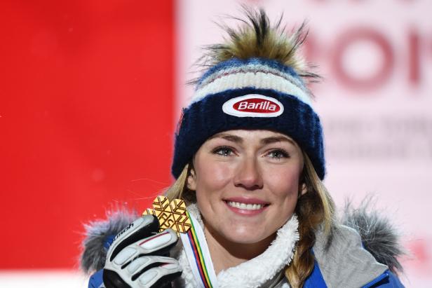 Eine Skirennläuferin mit einer Goldmedaille und einer Mütze mit dem Barilla-Logo.