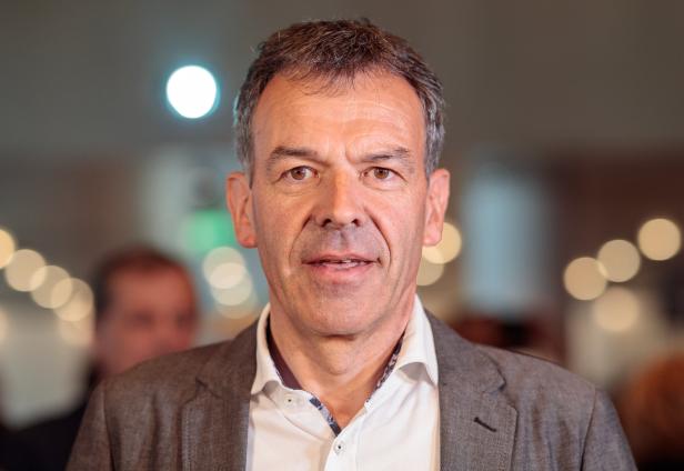 Porträt eines Mannes mit grauem Haar und einem grauen Sakko.