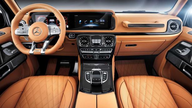 Innenraum eines Mercedes-Benz G-Klasse mit hellbraunen Ledersitzen und Carbon-Akzenten.