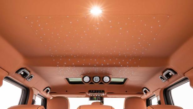 Der Innenraum eines Autos mit einem Dachhimmel, der mit kleinen Lichtern wie Sternen übersät ist.