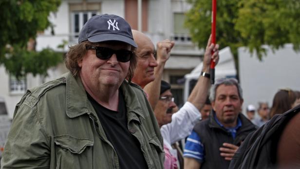 Foto:REUTERS/HUGO CORREIA Michael Moore bei einer Demonstration mit anderen Menschen.