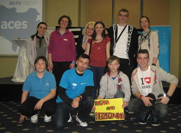 Eine Gruppe von Personen posiert mit einem Schild mit der Aufschrift „Bosnien und Herzegowina“.