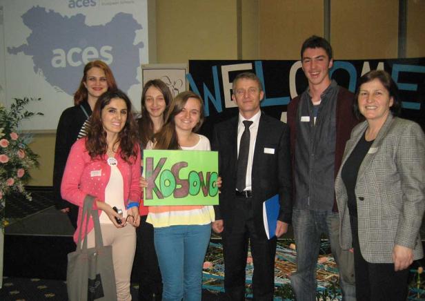 Eine Gruppe von Personen posiert mit einem Schild mit der Aufschrift „Kosovo“.