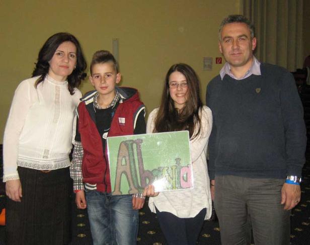 Eine Gruppe von vier Personen posiert mit einem Schild, auf dem „Albania“ steht.
