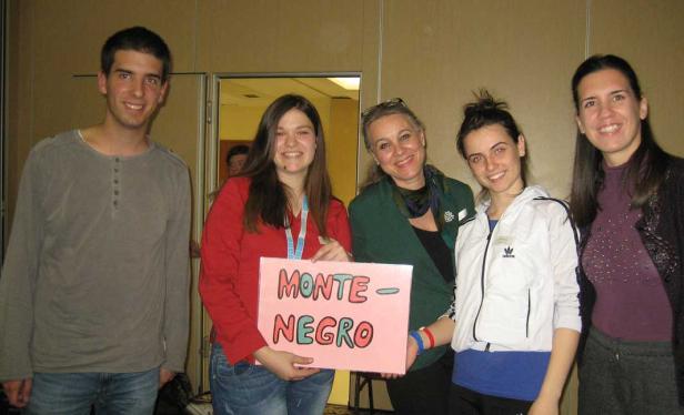 Eine Gruppe von fünf Personen hält ein Schild mit der Aufschrift „Monte-Negro“.