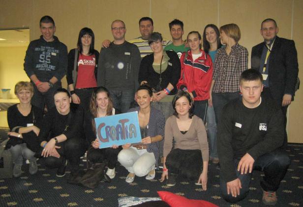 Eine Gruppe junger Leute posiert mit einem Schild mit der Aufschrift „Croatia“.