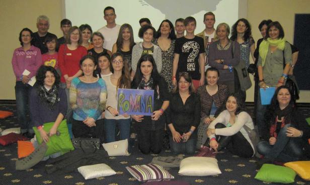 Eine Gruppe von Menschen posiert mit einem Schild „Romania“ für ein Foto.