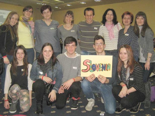 Eine Gruppe von Leuten posiert mit einem Schild mit der Aufschrift „Slovenia“.