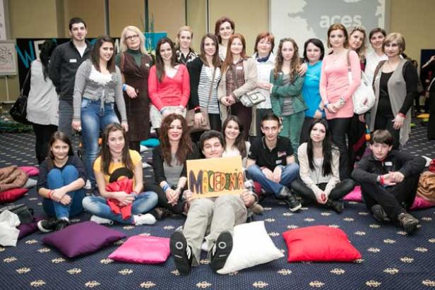 Eine Gruppe von Menschen posiert mit einem Schild mit der Aufschrift „Macedonia“ für ein Foto.