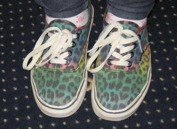 Ein Paar bunte Turnschuhe mit Leopardenmuster und weißen Schnürsenkeln.