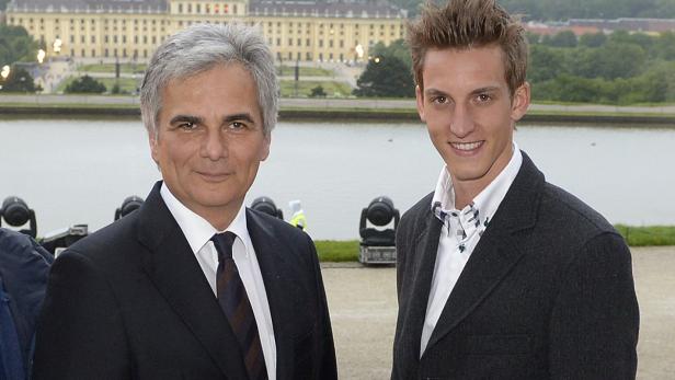 Zwei Männer in Anzügen posieren vor dem Schloss Schönbrunn in Wien.