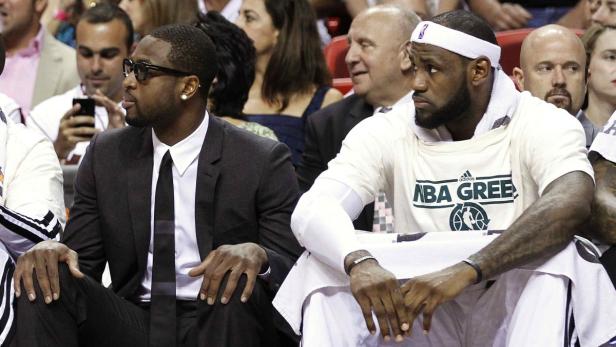 Dwyane Wade und LeBron James sitzen während eines Spiels auf der Bank.