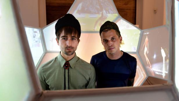 Zwei Männer stehen vor einer Installation aus Bildschirmen.