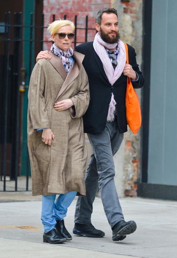 Tilda Swinton und ein Mann mit Bart spazieren auf der Straße.