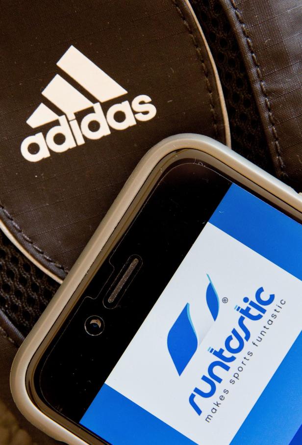 Ein Smartphone mit der Runtastic-App liegt auf einer Adidas-Tasche.