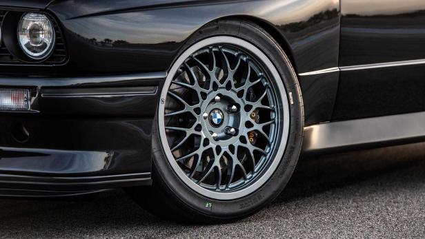 Detailaufnahme eines schwarzen BMW mit einer Felge im klassischen Design.