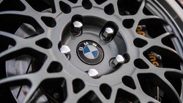 Nahaufnahme einer grauen BMW-Felge mit dem BMW-Logo in der Mitte.