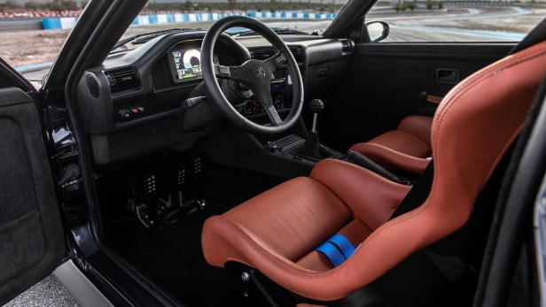 Innenraum eines schwarzen Autos mit braunen Ledersitzen und einem digitalen Armaturenbrett.