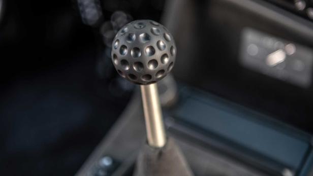 Ein Schaltknauf in Golfball-Optik im Innenraum eines Autos.