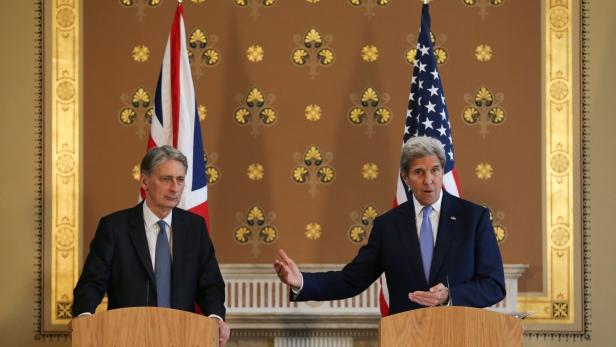 John Kerry und Philip Hammond bei einer Pressekonferenz vor britischen und amerikanischen Flaggen.