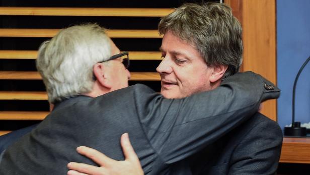 Zwei Männer in Anzügen umarmen sich.