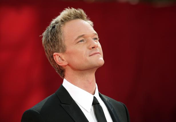 Neil Patrick Harris blickt auf einem roten Teppich nach oben.