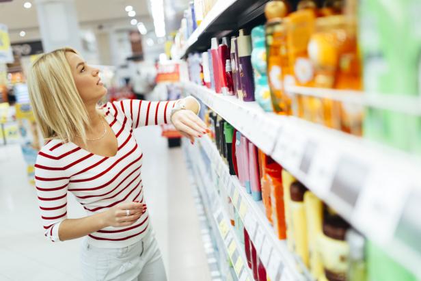 Beautiful woman buying body care products in supermarket