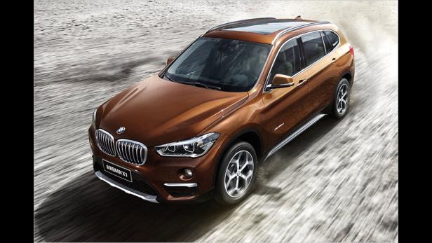 Ein brauner BMW X1 fährt auf einer Straße.