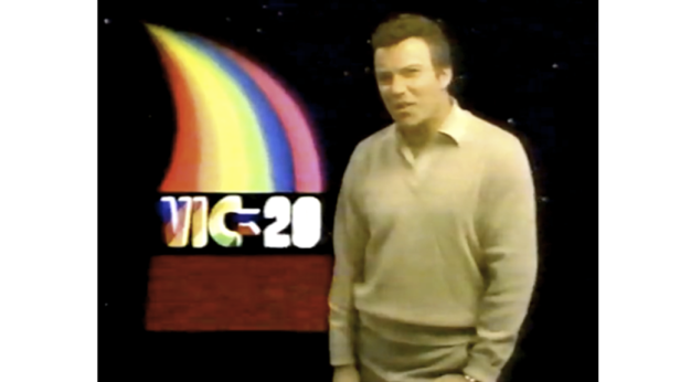 Ein Mann steht vor dem Logo des Commodore VIC-20 Computers.