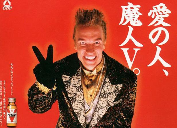 Arnold Schwarzenegger als „Magical V“ in einer japanischen Alinamin V-Werbung, der ein Victory-Zeichen macht.