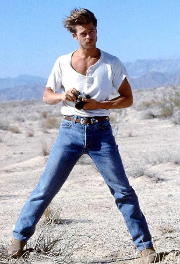 Brad Pitt steht in der Wüste und hält eine Kamera.