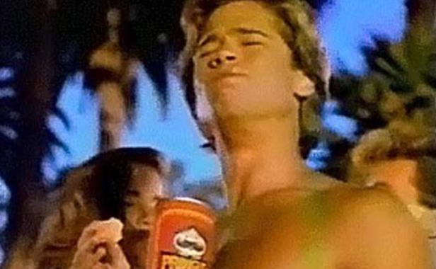Ein junger Mann isst Pringles-Chips vor einem tropischen Hintergrund.
