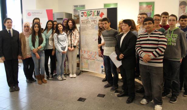 Eine Gruppe von Schülern steht vor einem Plakat zum Thema Berufsorientierung.