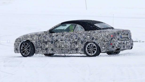 Ein getarntes Cabriolet fährt auf einer schneebedeckten Fläche.