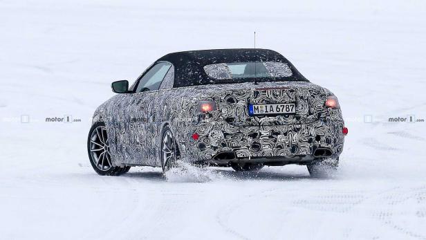 Ein Prototyp eines Cabrios mit Tarnmuster fährt auf einer schneebedeckten Fläche.