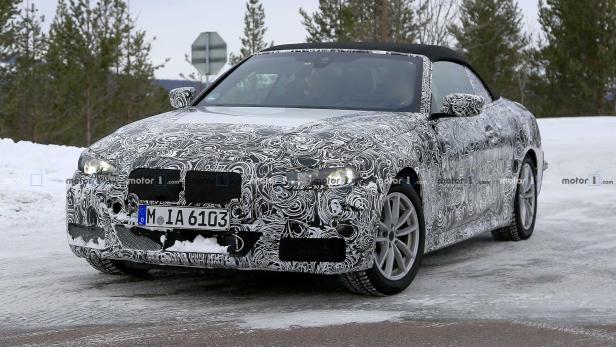 Ein Prototyp eines BMW Cabrios mit Tarnmuster fährt auf einer schneebedeckten Straße.