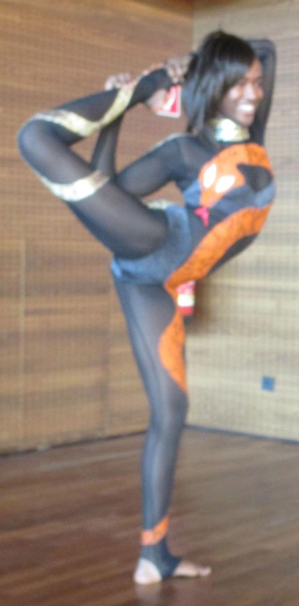 Eine Frau in einem Gymnastikanzug macht eine Yoga-Pose.