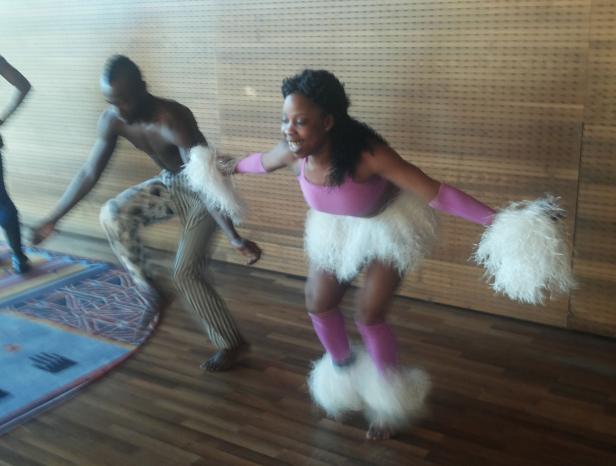 Zwei Tänzer in Kostümen führen eine Performance auf einer Bühne auf.