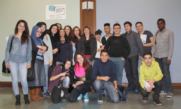 Eine Gruppe Jugendlicher posiert für ein Foto vor einem Kongress-Poster.