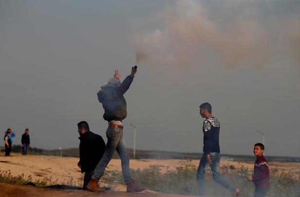 Palestinian demonstrator holds a tear gas canister fired by Israeli troops during a protest at the Israeli-Gaza border fence, east of Gaza City