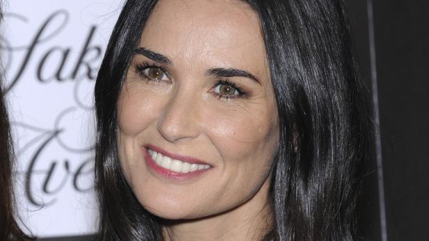 Nahaufnahme von Demi Moore mit dunklem, glänzendem Haar und einem strahlenden Lächeln.