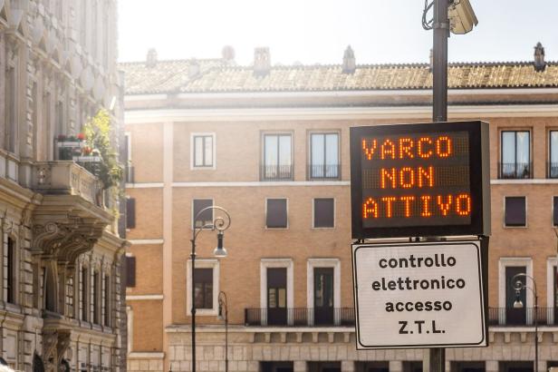 Elektronische Anzeigetafel mit der Aufschrift „VARCO NON ATTIVO“ und einem Schild für die Zufahrtskontrolle in einer Stadtstraße.