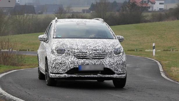 Ein mit einem Tarnmuster versehener Honda Jazz fährt auf einer Landstraße.