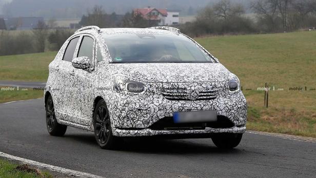 Ein mit einem Tarnmuster versehener Honda Jazz fährt auf einer Landstraße.