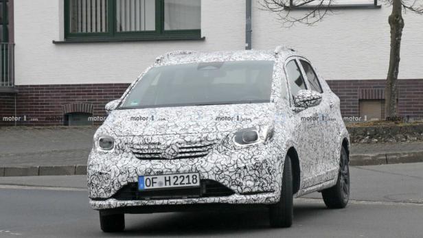 Ein mit einem Muster getarntes Auto fährt auf einer Straße.