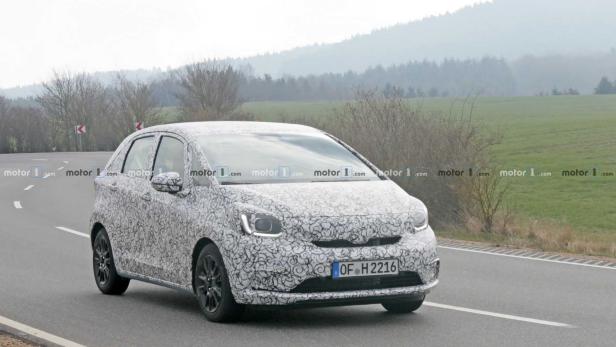 Ein mit Tarnmuster beklebter Honda Jazz fährt auf einer Landstraße.