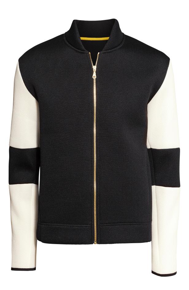 Eine schwarze Bomberjacke mit cremefarbenen Ärmeln und goldenem Reißverschluss.